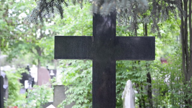 Cross in the cemetery in the rain 