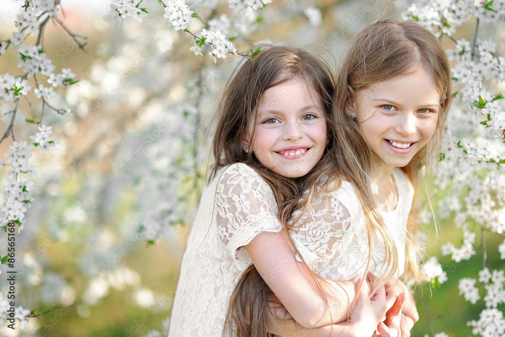 Wall mural Portrait of two little girls girlfriends spring