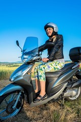 Fototapeta na wymiar Frau fährt Scooter auf dem Land