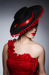 Woman wearing hat against dark background