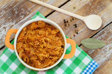Polish bigos in saucepan on rustic wooden surface
