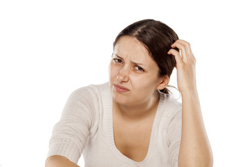 Fototapeta premium confused young woman scratching her head with her fingers