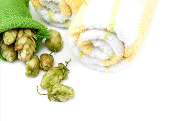Towels and hop on white background. Spa setting.