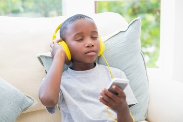 Little boy listening to music on the couch