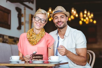 Cute couple on a date eating a piece of chocolate cake