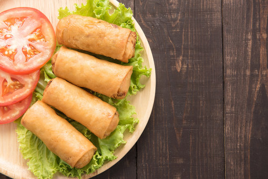 Fried Chinese traditional spring rolls on wooden background.
