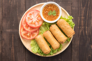 Fried Chinese traditional spring rolls on wooden background.