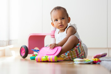Portrait of little African American little girl sitting on the f