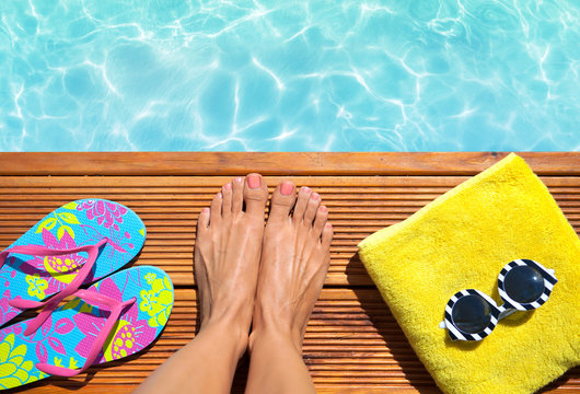 Summer holiday fashion concept - woman on a wooden pier at the pool