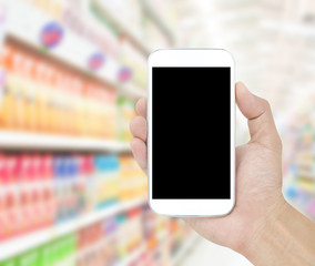 Hand holding mobile on Supermarket blur background