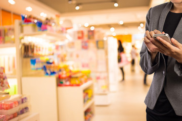 Women in shopping mall using mobile phone.