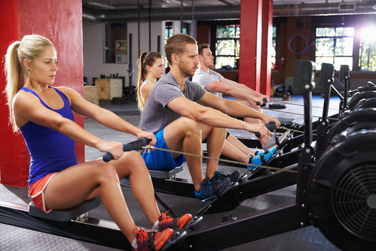 Gym Class Working Out On Rowing Machines Together
