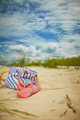 Fototapeta na wymiar Beach bag, flip flops on a beach