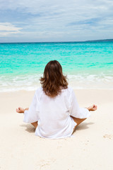 Fototapeta na wymiar Woman meditating on beach