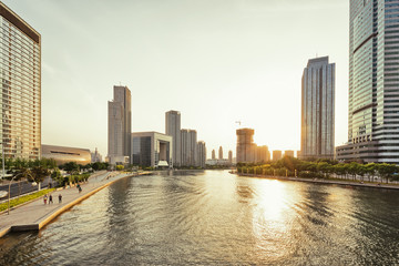 Obraz premium Modern skyline at riverbank during sunset