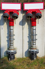 Fireplug. Red hydrant in the yard of a industrial factory.