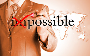 Businessman Hand turning the word Impossible into Possible with