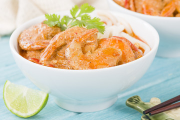 Thai Prawn Curry with Noodles - Thai red curry with prawns served with rice noodles in a white bowl.