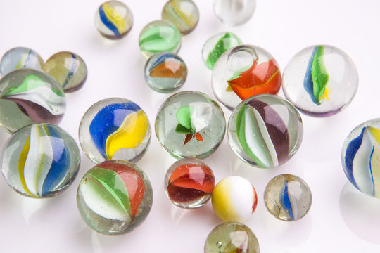 Biglie di vetro disposte su superficie riflettente