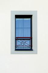 Ein modernes Alusprossenfenster mit Fensterbankgeländer in Neubaufassade