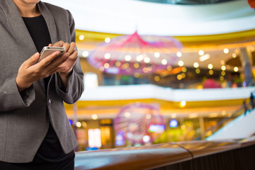 Women in shopping mall using mobile phone.