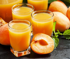 Fresh apricot juice and apricots with mint on black background,