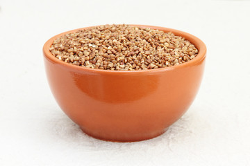 Buckwheat in brown ceramic bowl taken closeup.