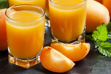Fresh apricot juice and apricots with mint on black background,
