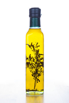 Olive oil in glass bottle with herb inside