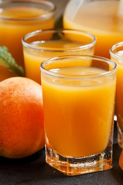 Fresh apricot juice and apricots with mint on black background,