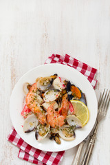 seafood salad on plate on white wooden background