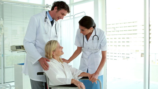 Doctors speaking with patient in wheelchair 