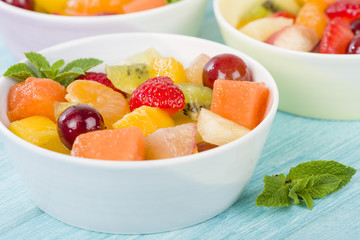 Fruit Salad - Bowls of fresh fruit salad on a blue background.