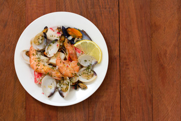 seafood salad on plate on brown wooden background
