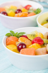 Fruit Salad - Bowls of fresh fruit salad on a blue background.