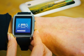 Composite image of businesswoman with smart watch on wrist