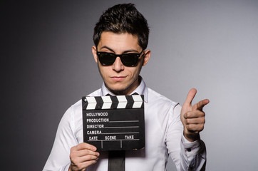 Obraz premium Young man in cool sunglasses holding chalkboard isolated on gray