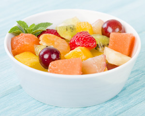 Fruit Salad - Bowl of fresh fruit salad on a blue background.
