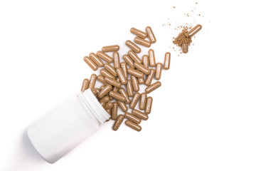 herb capsule from bottle on the white