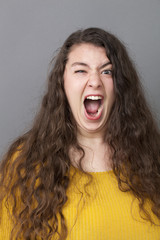 crazy overweight 20's woman with long brown hair making a face for expressing rage and anger