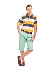 Young casual man leaning against a wall