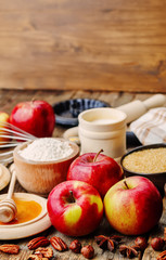 baking wood background with apples, nuts, honey, flour and butte