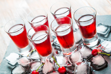 Red alcoholic cocktail with a cherry and ice