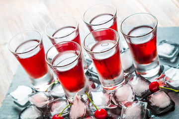 Red alcoholic cocktail with a cherry and ice