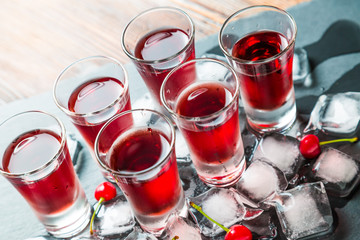 Red alcoholic cocktail with a cherry and ice