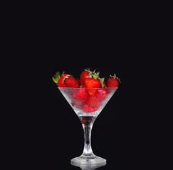 Strawberries in glass on black background
