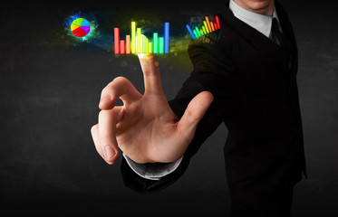 Handsome young business man touching colorful modern graph syste