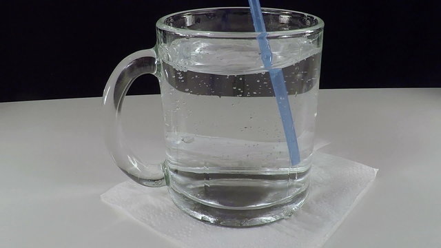 Mineral Water in a Glass Cup. Slow Motion. Bubbles of Carbon Dioxide Rise Up