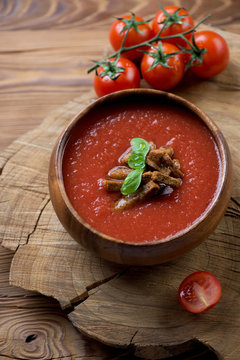 Gazpacho with croutons over wooden background, selective focus
