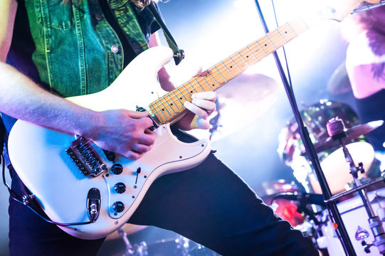 rock guitarist on stage under spotlights